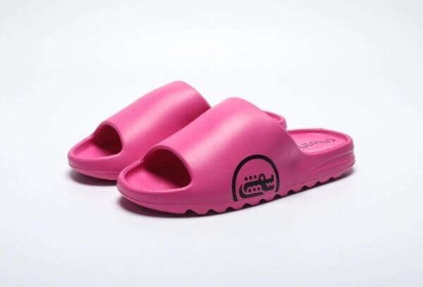 A pair of pink sandals on top of a white surface.