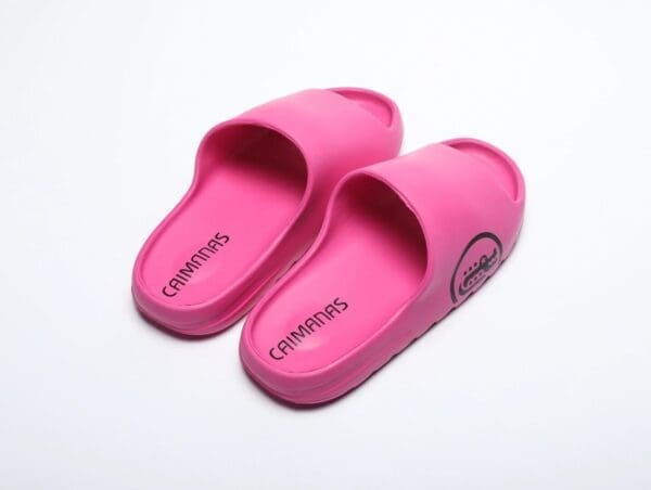 A pair of pink slippers on top of a white surface.