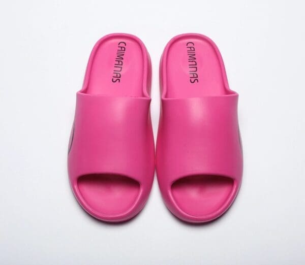 A pair of pink sandals on top of a white surface.