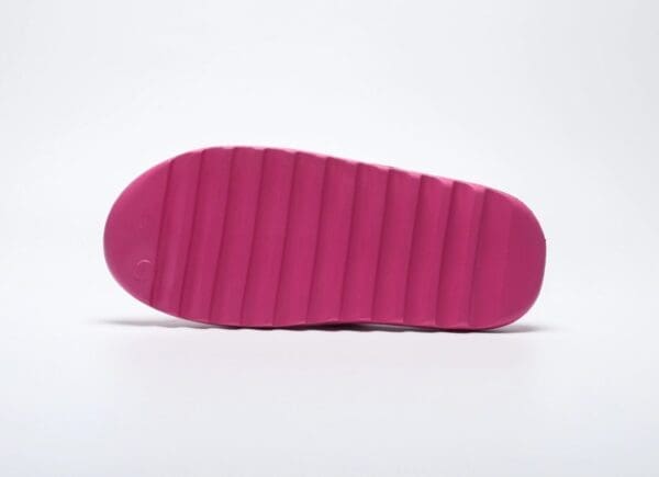 A pink shoe is shown with the bottom of it.