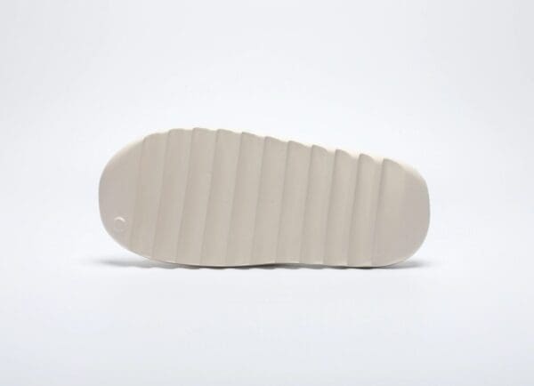 A white shoe is shown with the bottom of it.