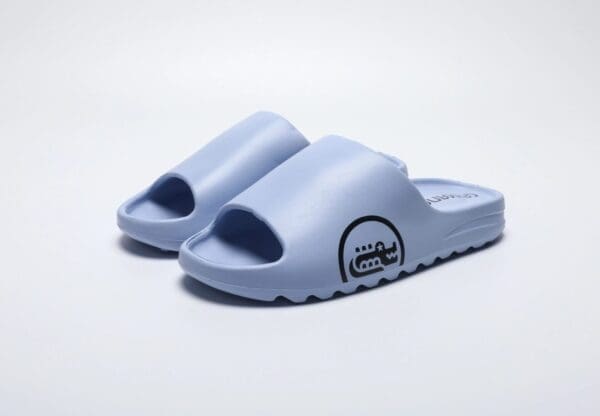 A pair of blue sandals on top of a white surface.