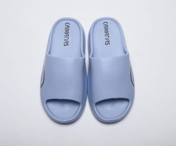 A pair of blue sandals on top of a white surface.