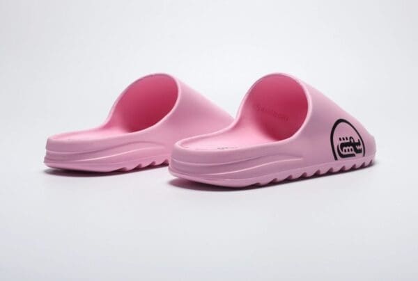 A pair of pink sandals on top of a white surface.