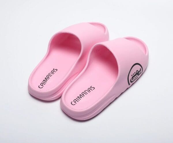 A pair of pink slippers on top of a white surface.