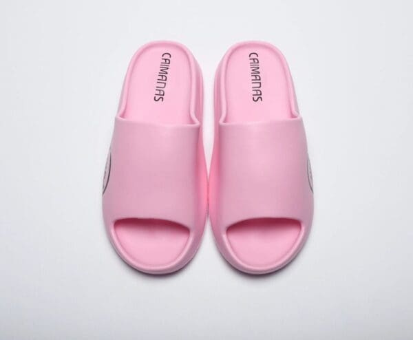 A pair of pink sandals on top of a white surface.