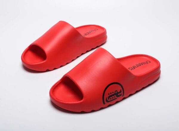 A pair of red sandals on top of a white surface.