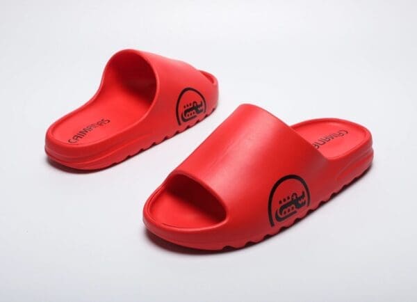 A pair of red sandals on top of a white surface.