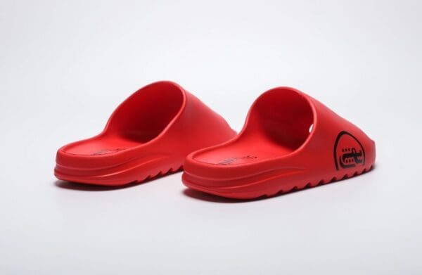 A pair of red sandals on top of a white surface.