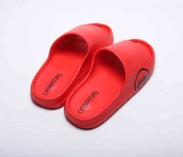 A pair of red slippers on top of a white surface.