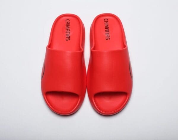 A pair of red sandals on top of a white surface.