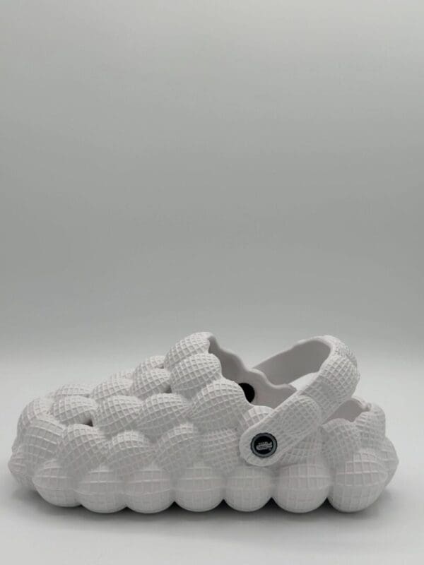 A white shoe with many balls on it