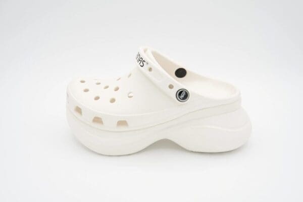 A white shoe with holes on the bottom of it.