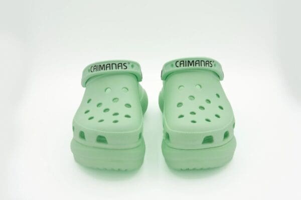 A pair of green crocs with the word crimpers on them.