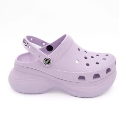 A pair of purple shoes with holes on them.