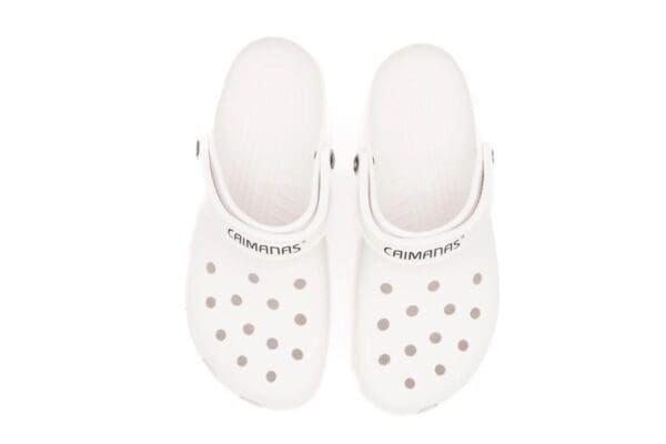 A pair of white crocs with a strap around the back.