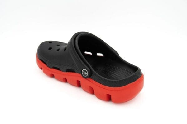 A pair of black and red crocs on top of a white background.