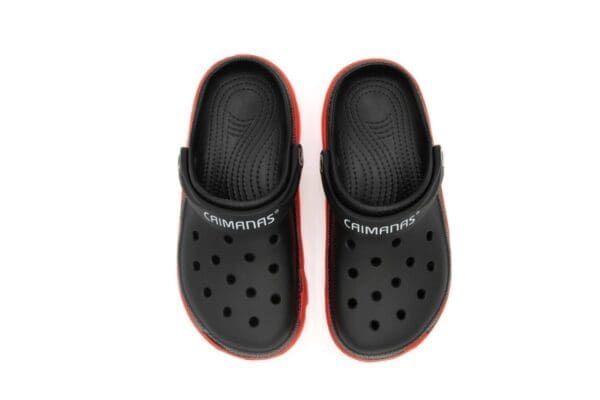 A pair of black and red crocs on top of each other.