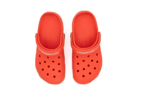 A pair of orange crocs with the word champion on them.