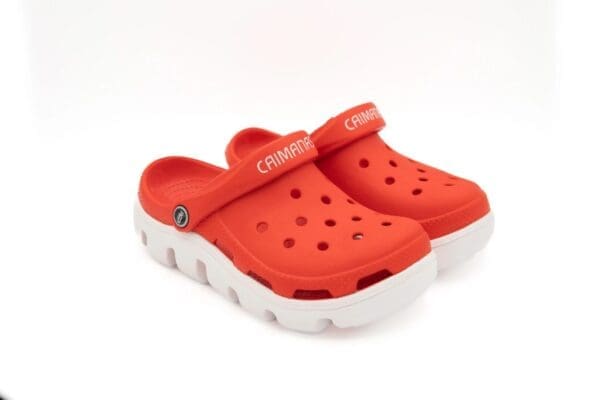 A pair of red crocs with white soles.