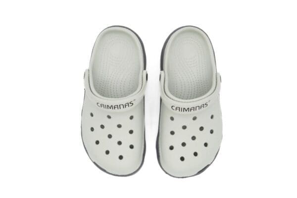 A pair of white crocs with black lettering on them.