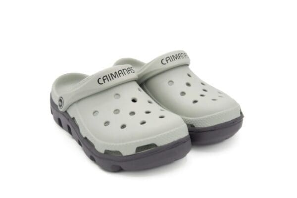 A pair of grey crocs with black soles.