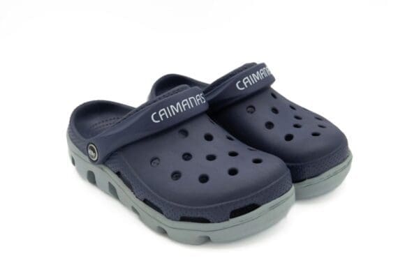 A pair of blue and grey crocs on a white background