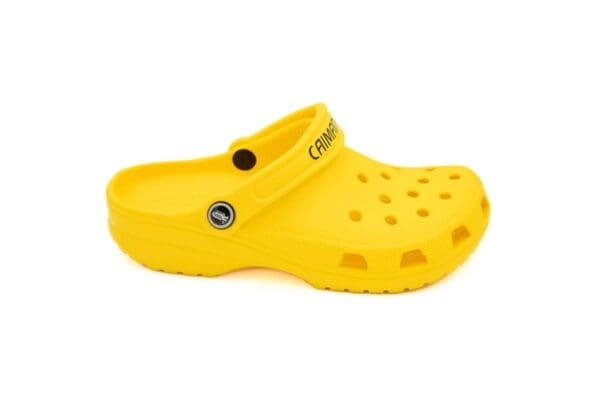 A yellow crocs shoe with black lettering on it.