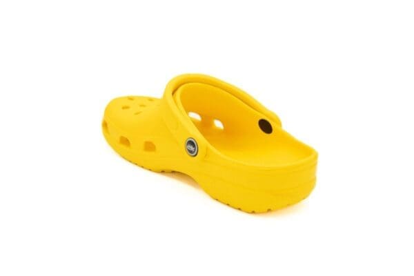 A pair of yellow crocs with holes in them.