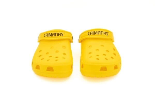 A pair of yellow crocks with the word crimmins written on them.