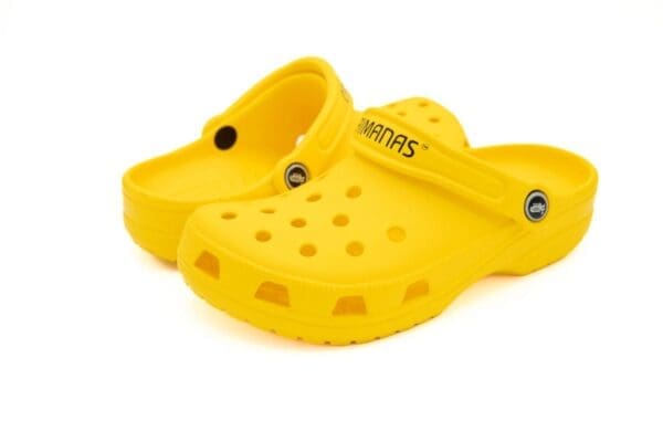 A pair of yellow crocs with black dots on them.