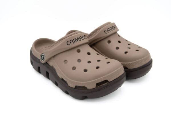 A pair of brown crocs with black soles.