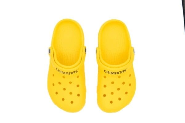 A pair of yellow crocs with the word " crocband " written on them.