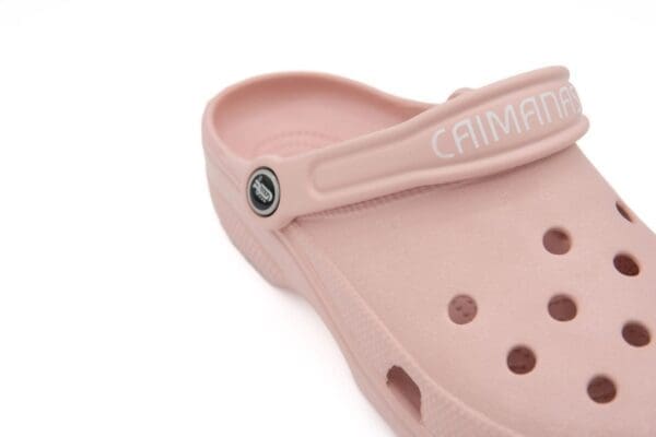 A close up of the strap on the bottom of a pink sandal.