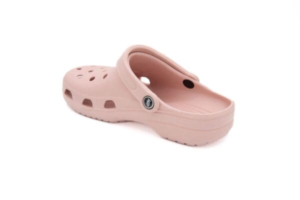 A pair of pink crocs with a button on the side.