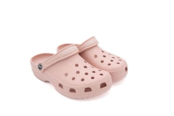 A pair of pink crocs with a strap around the top.