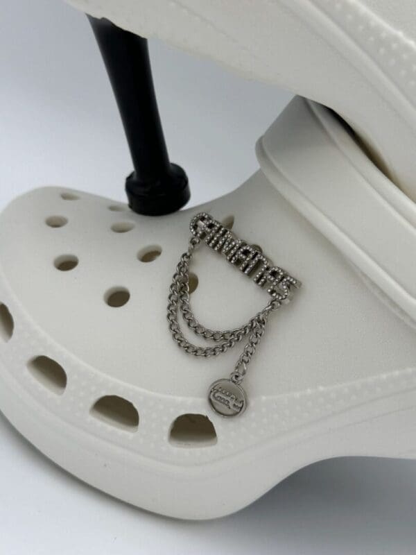 A pair of white shoes with chains on them.